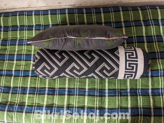 একটি সিঙ্গেল তোশক , কোল বালিশ এবং বালিশ